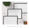 Set of planner sheets with text labels on a white surface with a plant and fruit.